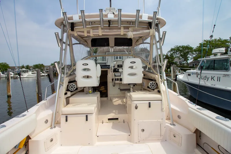 Slide: The Image of The image shows the cockpit of a 2004 Grady-White Marlin 300. It features white seats and fishing rod holders. - 38