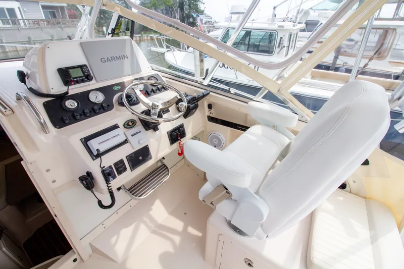 Slide: The Image of The cockpit of a 2004 Grady-White Marlin 300 with a Garmin navigation system and white seating. - 42