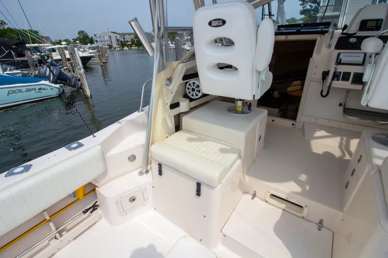 Slide: The Image of The image shows the cockpit of a 2004 Grady-White Marlin 300 with white seating. - 37