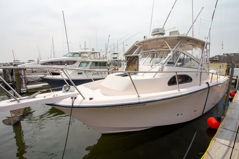 Slide: The Image of A 2004 Grady-White Marlin 300 docked, with other boats visible in the background. - 2