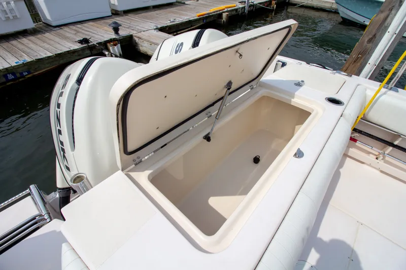 Slide: The Image of A 2004 Grady-White Marlin 300 with an open storage compartment at the stern, near a dock. - 21