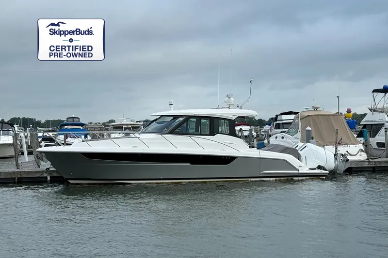 The Image of 2026 Tiara Yachts 39 LE docked in a marina, surrounded by other boats, under a gray sky. - 0