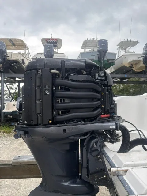 Slide: The Image of An outboard motor is mounted on a boat trailer. Several boats are stacked in the background. - 4