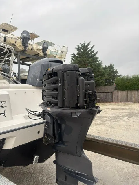Slide: The Image of An outboard motor is mounted on the stern of an Edgewater 245CX Crossover boat on a trailer. - 5