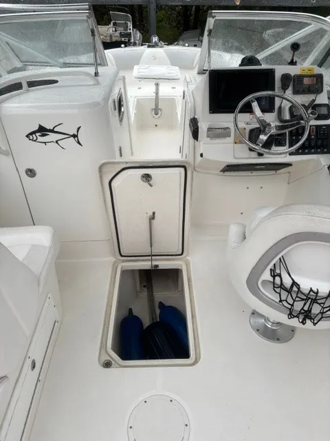 Slide: The Image of The image shows the cockpit of a 2010 Edgewater 245CX Crossover boat with helm and storage. - 9