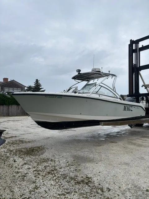 Slide: The Image of A 2010 Edgewater 245CX Crossover boat being lifted by a crane. It features a white hull design. - 1