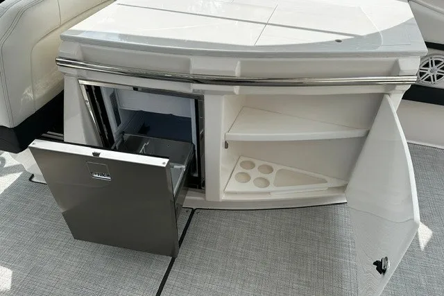 Slide: The Image of 2027 Regal 3300 boat interior with open mini fridge and storage shelves. - 26