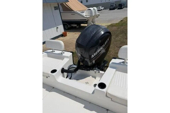 Slide: The Image of 2013 Boston Whaler 21 Montauk boat with Mercury outboard motor, docked outdoors. - 15
