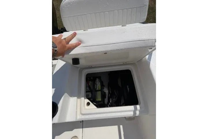 Slide: The Image of 2013 Boston Whaler 21 Montauk storage compartment with open lid, revealing interior contents. - 29