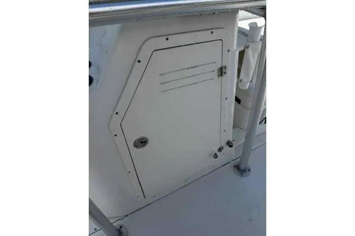 Slide: The Image of 2013 Boston Whaler 21 Montauk boat storage compartment with secure latch and railing. - 21
