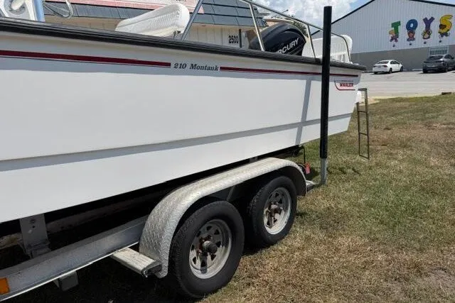 Slide: The Image of 2013 Boston Whaler 21 Montauk boat on trailer, parked near a toy store. - 5