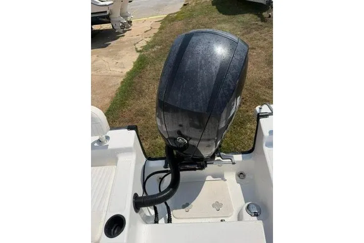 Slide: The Image of Outboard motor on a 2013 Boston Whaler 21 Montauk boat, parked on grass. - 26