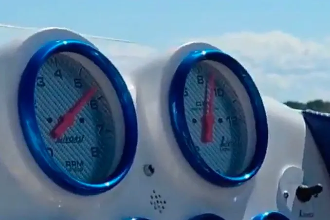 Slide: The Image of Dashboard gauges of a 2021 Activator 30 boat, featuring blue accents and clear skies. - 17