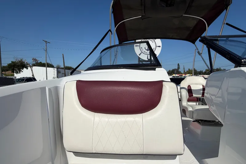 Slide: The Image of 2019 Tahoe 550 TS boat interior with maroon and white seating under a clear blue sky. - 43