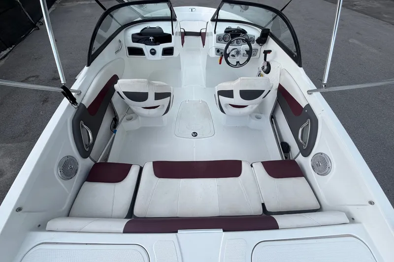 Slide: The Image of 2019 Tahoe 550 TS boat interior with white and maroon seating, steering wheel, and dashboard. - 13