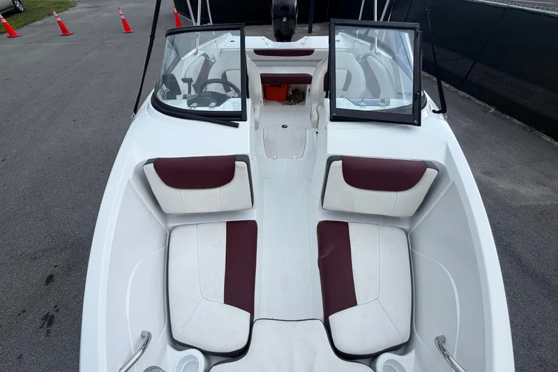 Slide: The Image of 2019 Tahoe 550 TS boat interior with maroon and white seating, open windshield, and steering wheel. - 37