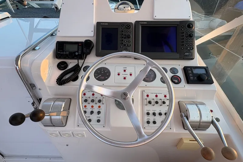 Slide: The Image of Helm of 2002 Cabo 31 Express boat with steering wheel and navigation controls. - 10