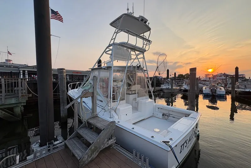 Slide: The Image of Cabo 31 Express 2002 docked at sunset with American flag in background. - 2