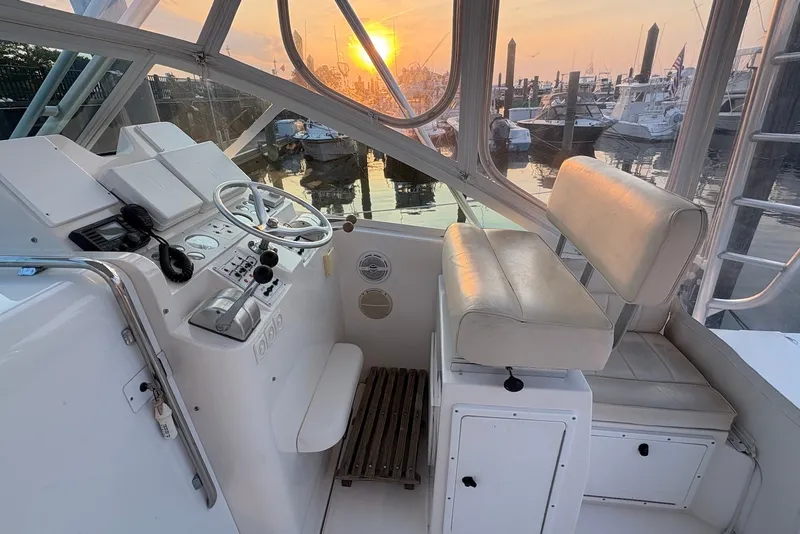 Slide: The Image of 2002 Cabo 31 Express helm with sunset view at marina. - 9