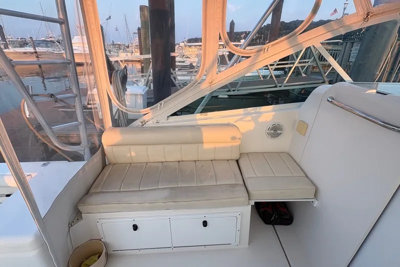 Slide: The Image of 2002 Cabo 31 Express boat interior with beige seating and marina view. - 8