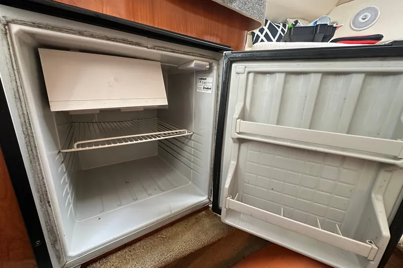 Slide: The Image of Open refrigerator inside a 2006 Larson Cabrio 240 boat cabin. - 13