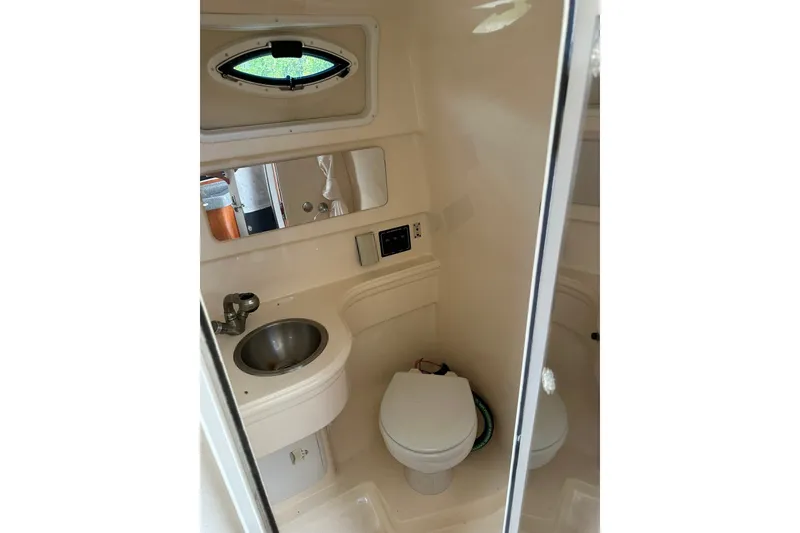 Slide: The Image of 2006 Larson Cabrio 240 boat bathroom with sink, toilet, and mirror. - 14