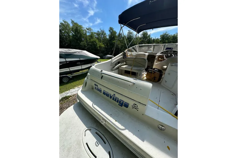 Slide: The Image of 2006 Larson Cabrio 240 boat with canopy, parked outdoors on a sunny day. - 8