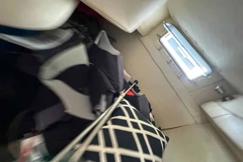 Slide: The Image of Interior cabin of a 2006 Larson Cabrio 240 boat with window and cushions. - 15