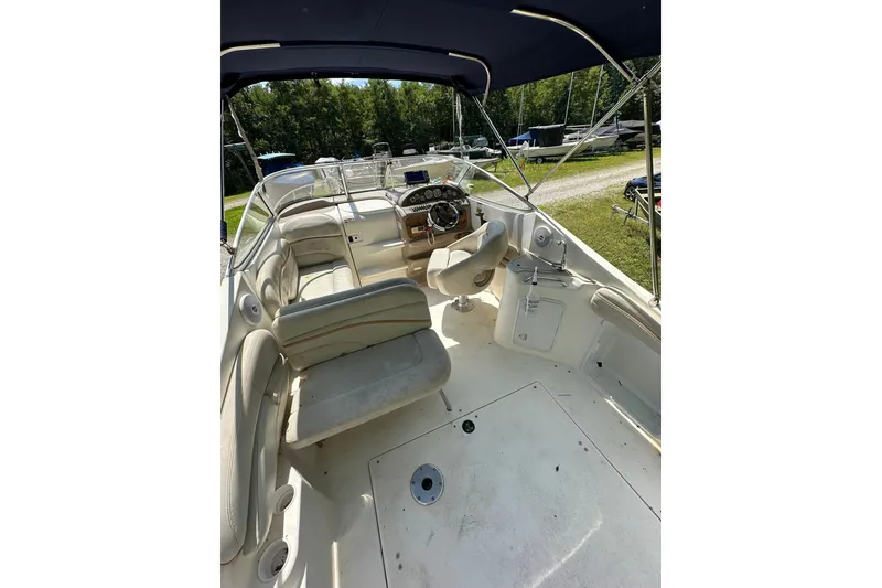 Slide: The Image of 2006 Larson Cabrio 240 boat interior with seating and steering wheel under canopy. - 20