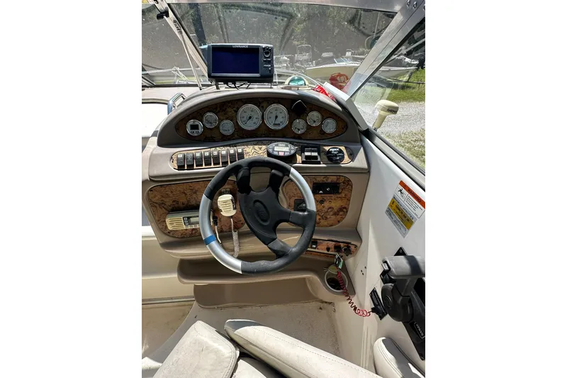 Slide: The Image of 2006 Larson Cabrio 240 boat dashboard with steering wheel and navigation instruments. - 18