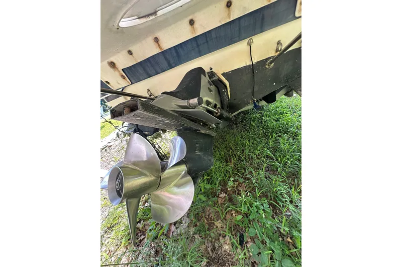 Slide: The Image of 2006 Larson Cabrio 240 boat propeller and stern, resting on grass. - 7