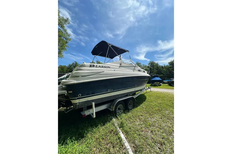 Slide: The Image of 2006 Larson Cabrio 240 boat on trailer under clear blue sky. - 5