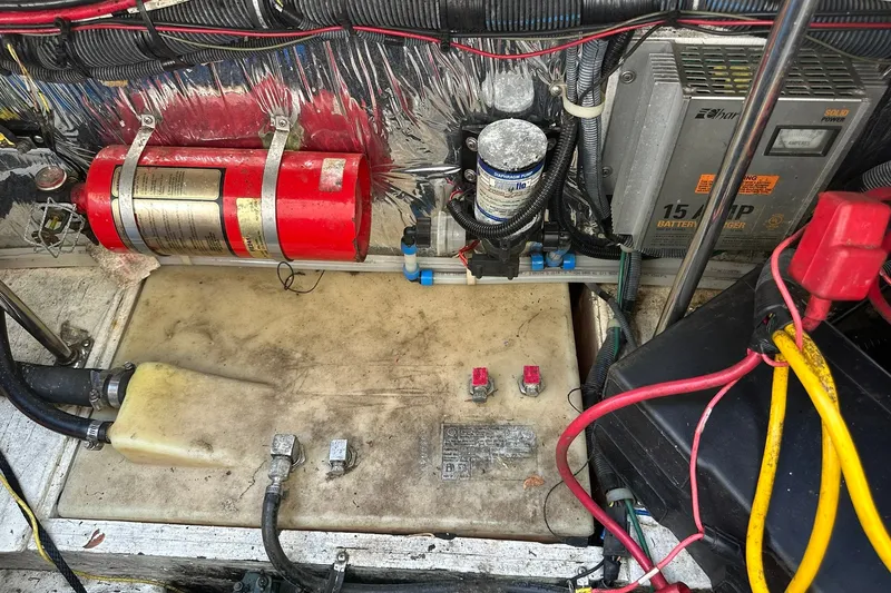 Slide: The Image of Engine compartment of a 2006 Larson Cabrio 240 with battery charger and fire extinguisher. - 25