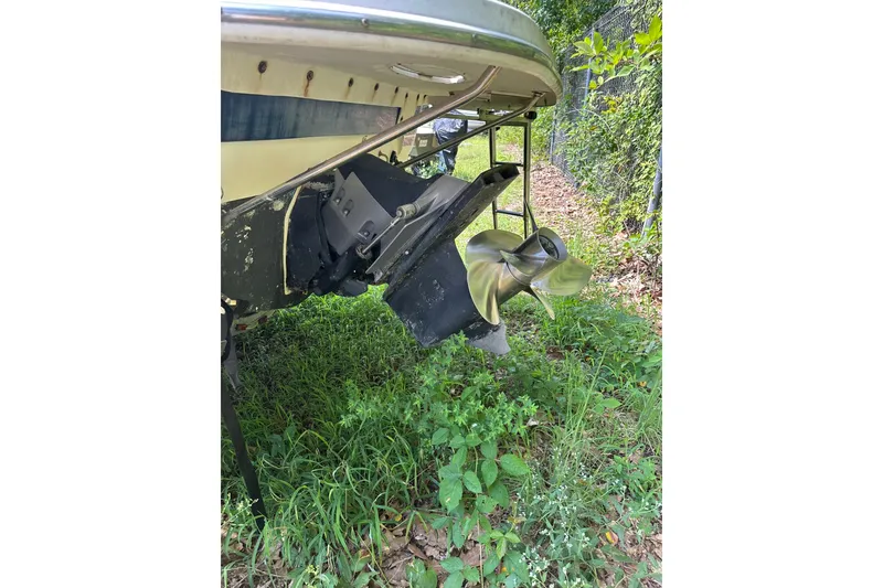 Slide: The Image of Rear view of a 2006 Larson Cabrio 240 boat's propeller and outdrive in grassy area. - 27