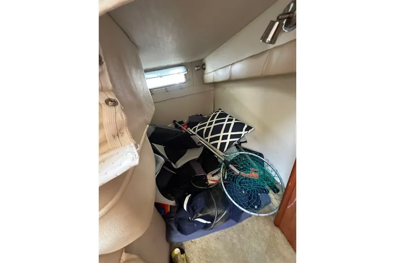 Slide: The Image of Interior cabin storage of 2006 Larson Cabrio 240 boat with fishing gear and pillow. - 16