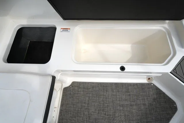Slide: The Image of 2018 Sea Ray SPX 210 boat storage compartment with carpeted flooring. - 17