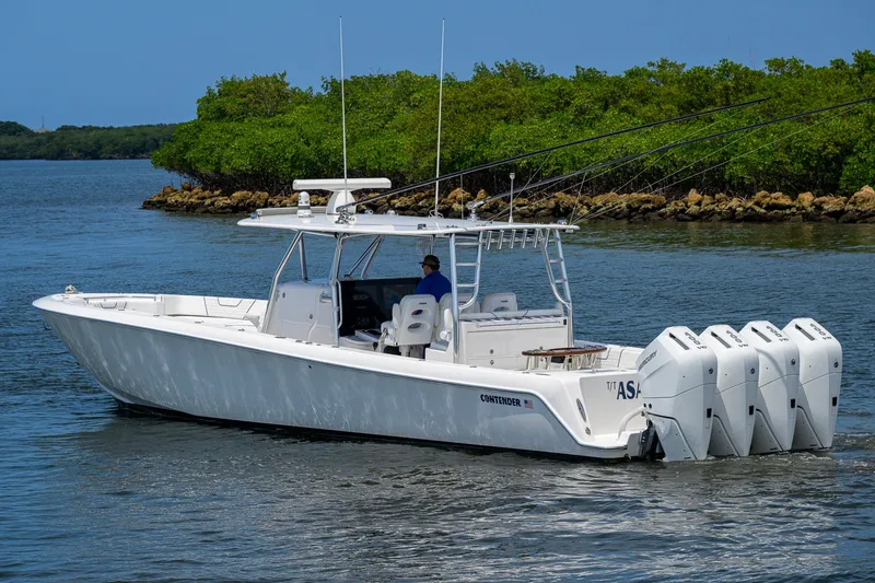 Slide: The Image of 2023 Contender 44 ST boat with multiple engines cruising on a calm waterway. - 6