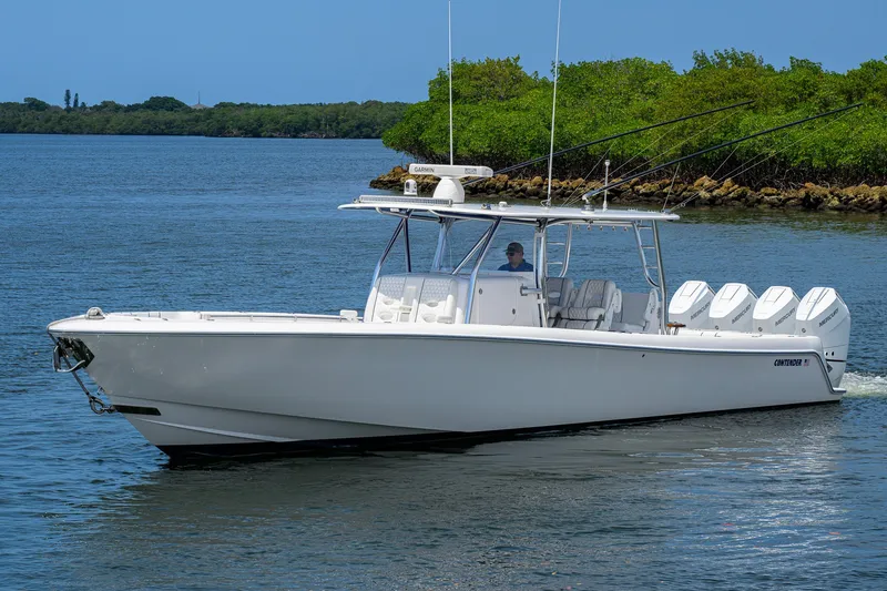 Slide: The Image of 2023 Contender 44 ST boat cruising on a calm waterway with lush greenery. - 3