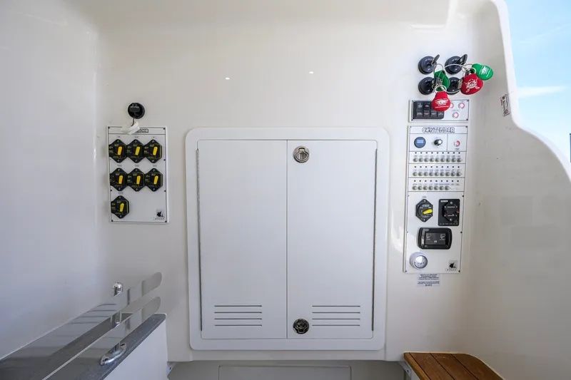 Slide: The Image of Control panel of 2023 Contender 44 ST boat with switches and storage compartment. - 65