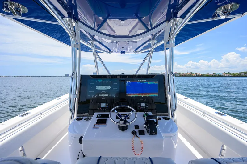 Slide: The Image of 2023 Contender 44 ST boat cockpit with advanced navigation system on open water. - 11