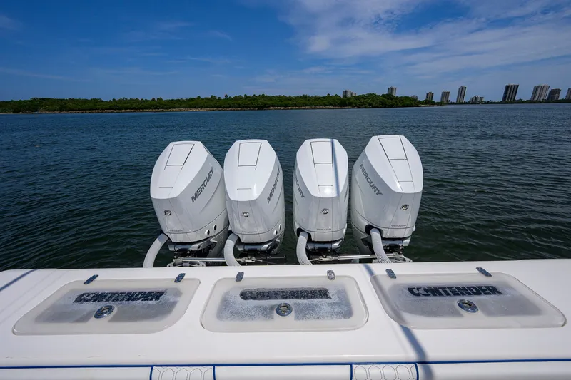 Slide: The Image of Four Mercury outboard engines on a 2023 Contender 44 ST boat, with a scenic water backdrop. - 51