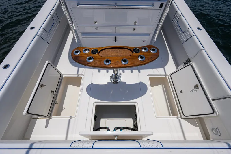 Slide: The Image of 2023 Contender 44 ST boat deck with storage compartments and wooden rod holder. - 58