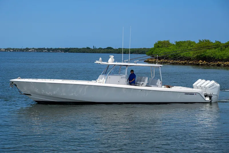 Slide: The Image of 2023 Contender 44 ST boat cruising on calm waters under a clear blue sky. - 4