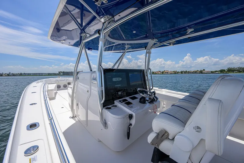 Slide: The Image of 2023 Contender 44 ST boat interior with sleek helm and seating, cruising on a sunny day. - 13