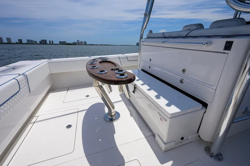 Slide: The Image of 2023 Contender 44 ST boat deck with rod holders and storage, overlooking a coastal skyline. - 45