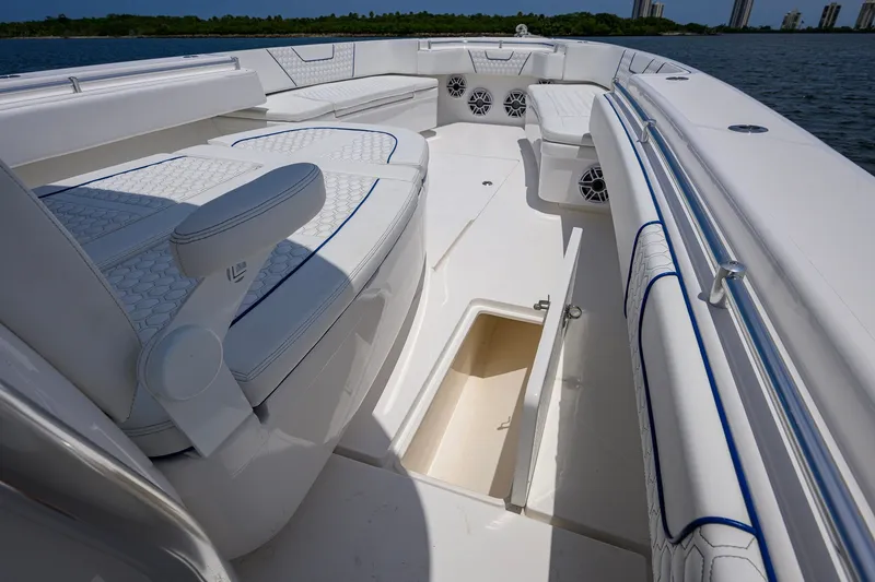 Slide: The Image of 2023 Contender 44 ST boat interior with white seating and open storage compartment. - 29