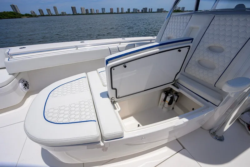 Slide: The Image of 2023 Contender 44 ST boat interior with open storage compartment, white cushioned seating. - 26