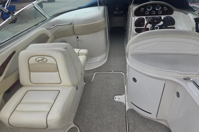 Slide: The Image of 2001 Sea Ray 290 Bow Rider interior with beige seating and dashboard controls. - 12