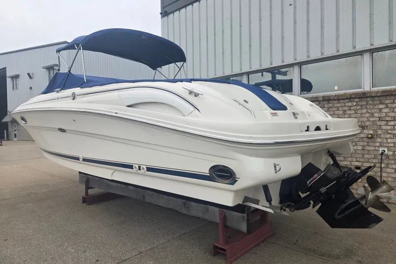 Slide: The Image of 2001 Sea Ray 290 Bow Rider boat with blue canopy, docked outdoors. - 2