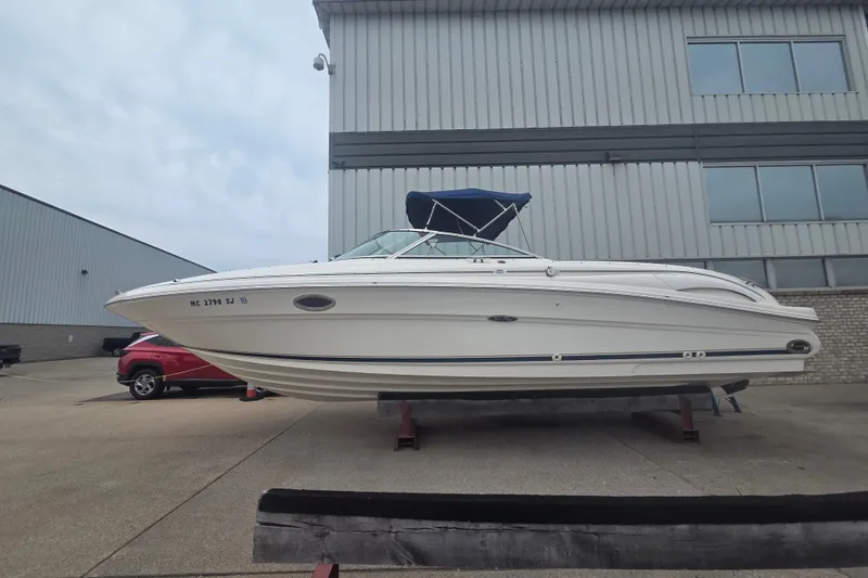 Slide: The Image of 2001 Sea Ray 290 Bow Rider boat on display outside industrial building. - 1